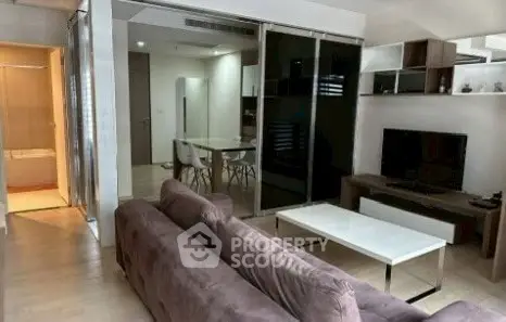 Modern living room with sleek furniture and open dining area, perfect for stylish urban living.