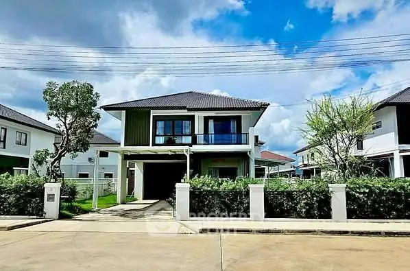 Modern two-story house with lush greenery and clear blue sky