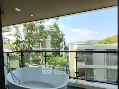 Luxurious balcony with freestanding bathtub and stunning view of modern buildings and lush greenery.