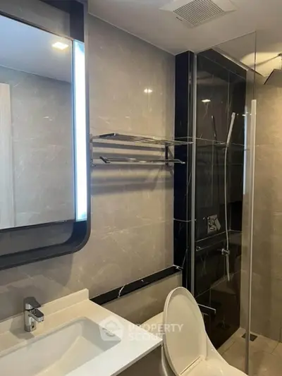 Modern bathroom with glass shower and sleek fixtures.