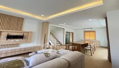 Spacious modern living room with elegant wooden accents and open dining area.