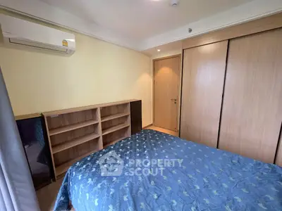 Cozy bedroom with built-in wardrobe and air conditioning in modern apartment.
