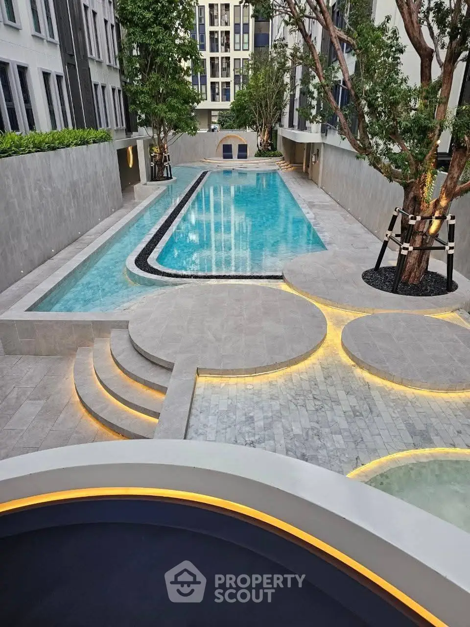 Luxurious modern apartment complex with stunning outdoor pool and elegant landscaping.