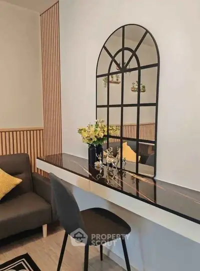 Stylish modern living room with elegant decor and chic furniture, featuring a sleek black table and decorative mirror.