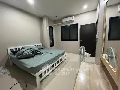 Spacious bedroom with modern decor and air conditioning, perfect for comfortable living.