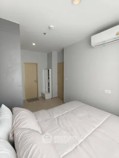 Modern bedroom with minimalist decor and air conditioning in a stylish apartment.