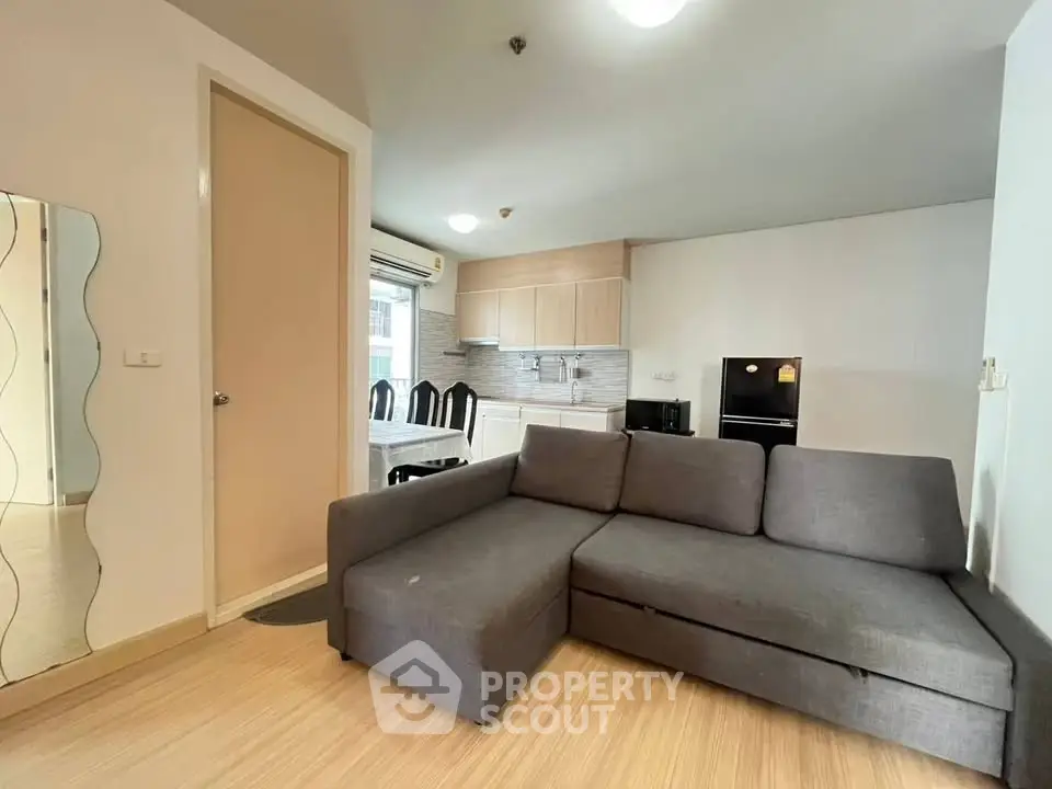 Modern living room with sleek gray sofa and open kitchen layout