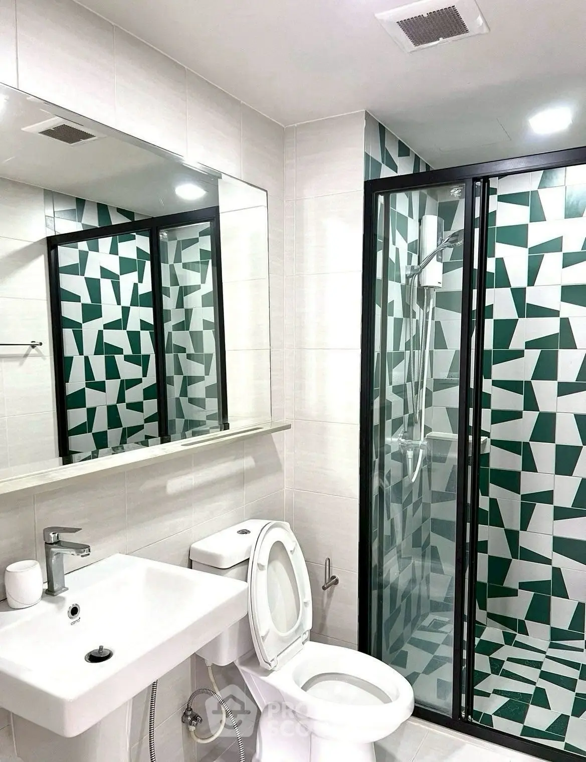 Modern bathroom with geometric tile design and glass shower enclosure.