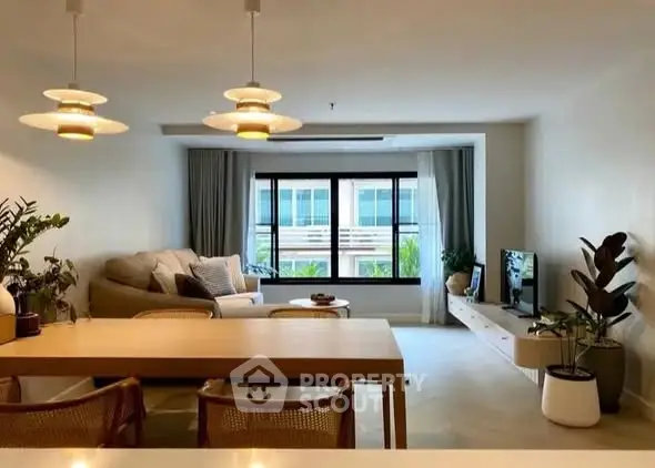 Spacious modern living room with stylish decor and large window view.