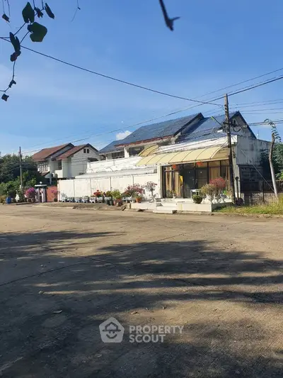 Charming residential street view with houses and clear blue sky.