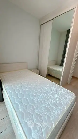 Spacious bedroom with large mirrored wardrobe and comfortable bed