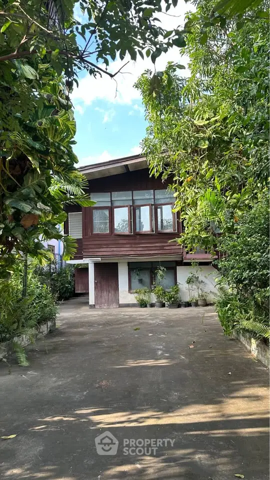 Charming wooden house with lush greenery and spacious driveway