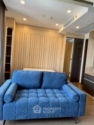 Modern living room with stylish blue sofa and wooden paneling, perfect for cozy relaxation.