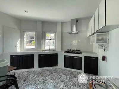 Modern kitchen with stylish black cabinets and patterned tile flooring