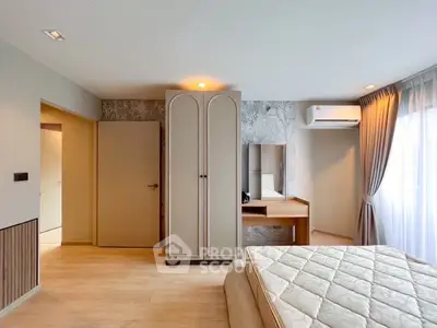 Spacious bedroom with elegant decor and natural light, featuring a built-in wardrobe and cozy ambiance.