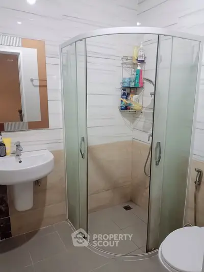 Modern bathroom with glass shower enclosure and sleek fixtures