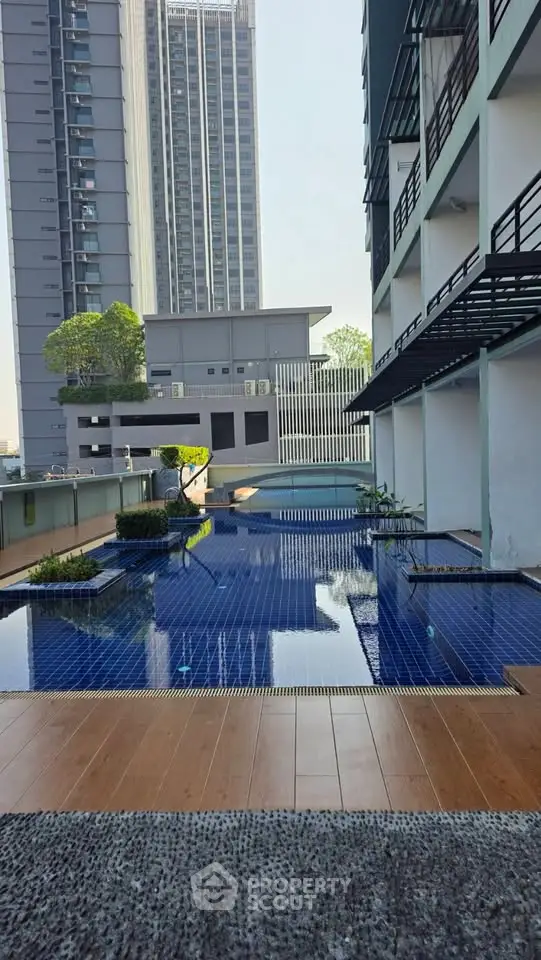 Luxurious urban apartment complex with modern pool and skyline view, perfect for city living.