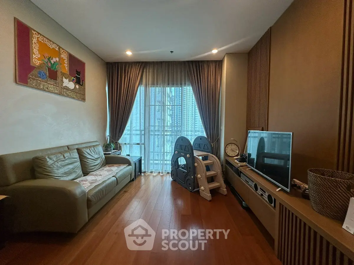 Stylish living room with modern decor and large window offering city views, perfect for urban living.