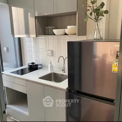 Modern compact kitchen with sleek cabinetry and stainless steel appliances