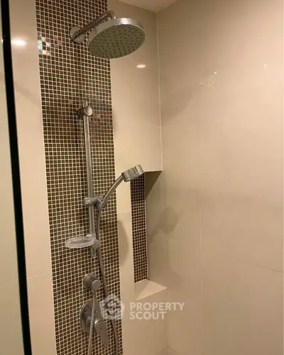 Modern bathroom shower with sleek tile design and rainfall showerhead.
