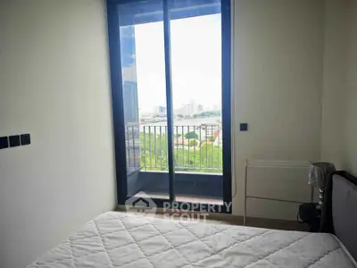 Bright bedroom with large window and city view, featuring a cozy bed and modern decor.