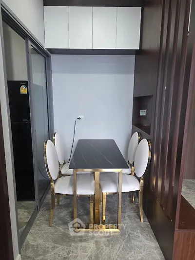 Modern dining area with elegant chairs and sleek table in a compact space