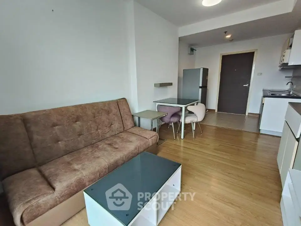 Modern living room with cozy sofa and open kitchen layout in a stylish apartment.