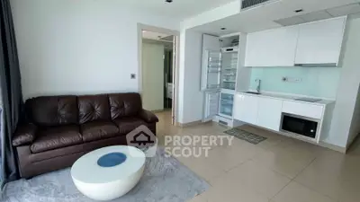 Modern open-layout living room with sleek kitchen and leather sofa, perfect for urban living.