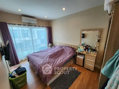 Cozy bedroom with modern decor and natural light, featuring a large bed and vanity area.