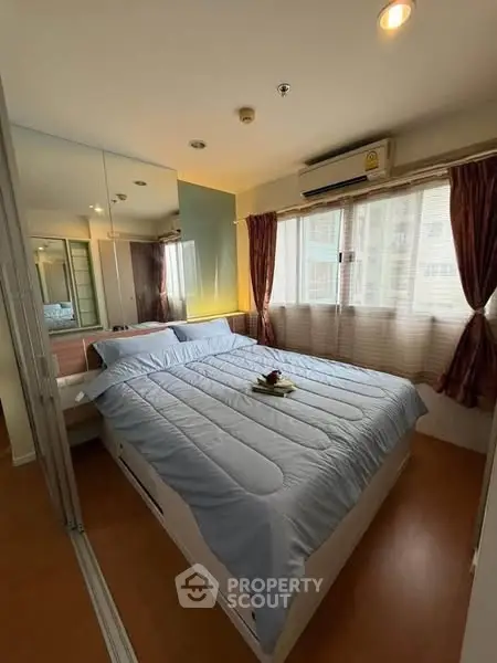 Cozy bedroom with large windows and mirrored closet in modern apartment.