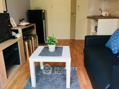 Cozy living room with modern decor and compact kitchen area, perfect for urban living.