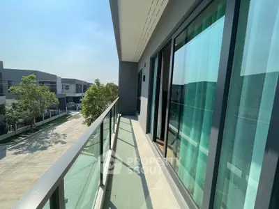 Spacious balcony with modern glass railing and serene neighborhood view