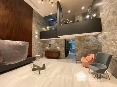 Luxurious living room with high ceiling, elegant stone wall, modern furniture, and sophisticated lighting fixtures, perfect for upscale living.