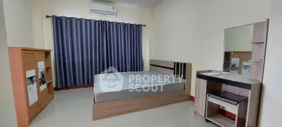 Spacious bedroom with modern furniture and large window for natural light.