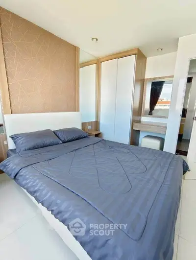 Modern bedroom with stylish decor and ample natural light, featuring a comfortable bed and sleek wardrobe.