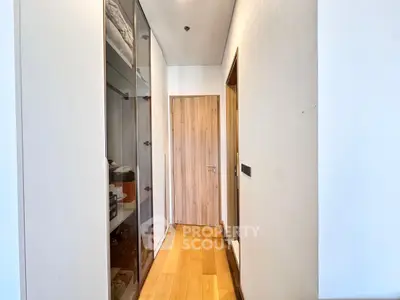 Modern hallway with wooden flooring and sleek storage cabinets in a contemporary apartment.