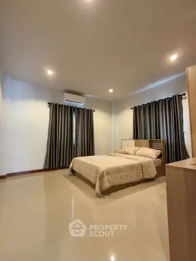 Spacious bedroom with modern decor and natural lighting