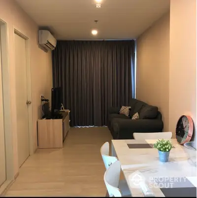 Modern living room with cozy sofa and dining area, featuring elegant decor and natural light.