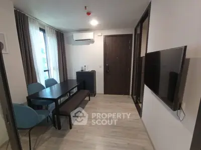 Modern apartment dining area with sleek furniture and wall-mounted TV