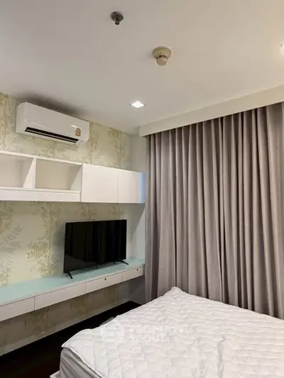 Modern bedroom with air conditioning and TV, featuring elegant curtains and stylish decor.