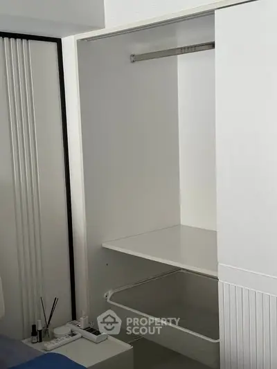 Modern white closet with sliding doors and storage basket in a stylish bedroom.