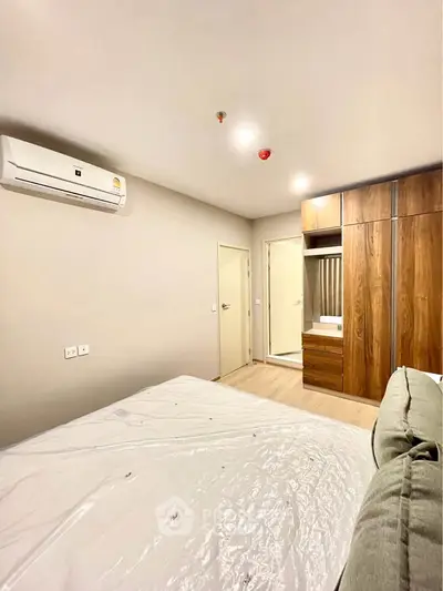 Modern bedroom with air conditioning and wooden wardrobe in a stylish apartment.