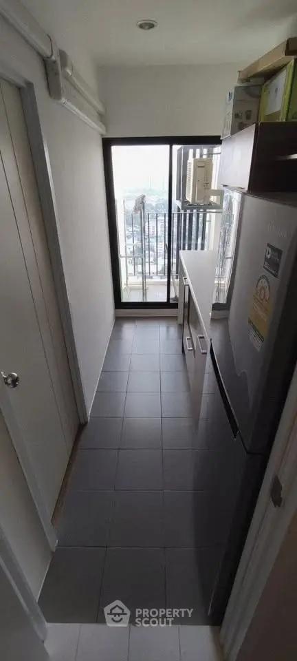 Compact kitchen with balcony view in modern apartment