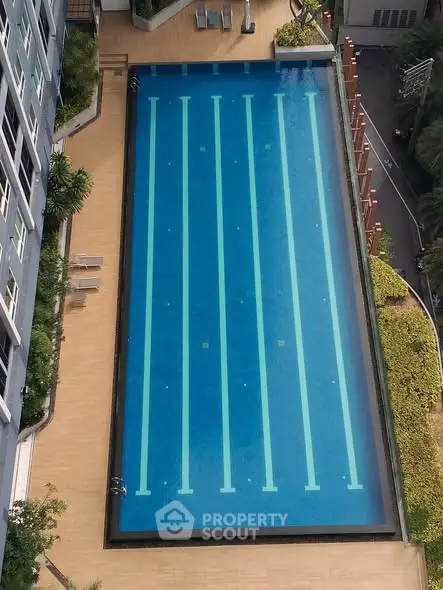 Luxurious rooftop swimming pool with spacious deck in modern high-rise building.