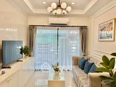 Elegant living room with modern decor, plush sofa, and large TV, perfect for relaxation and entertainment.