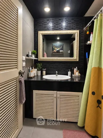Charming bathroom with stylish black tile accents and modern fixtures, perfect for a cozy home retreat.