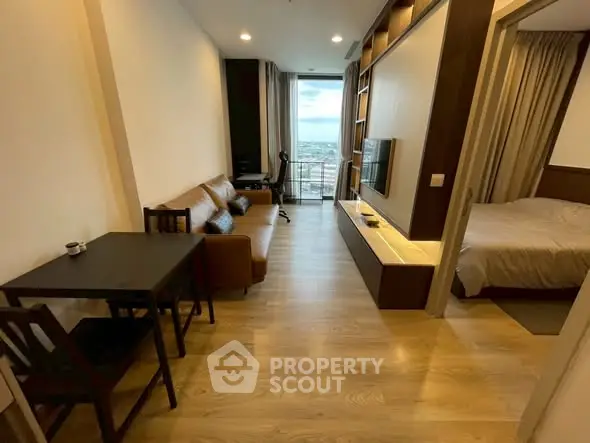 Modern apartment with open living room and bedroom, featuring stylish furniture and a city view.