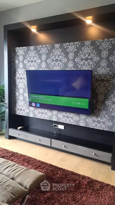 Modern living room with stylish TV wall unit and elegant wallpaper design.