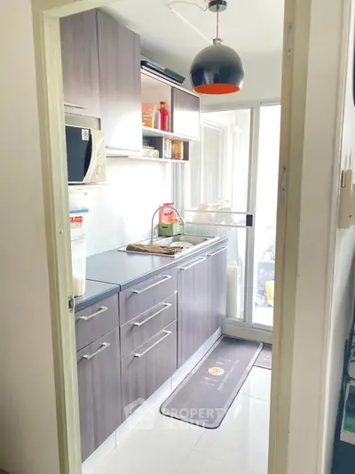 Modern kitchen with sleek cabinetry and natural light, featuring a compact yet functional design.