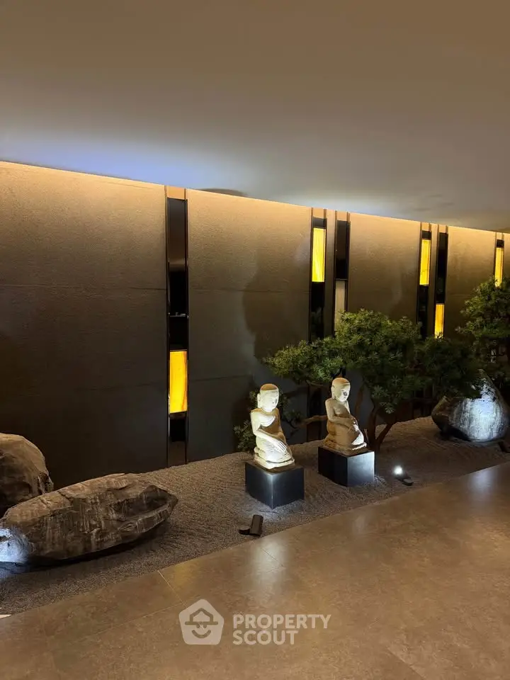 Elegant modern building entrance with sculptures and ambient lighting